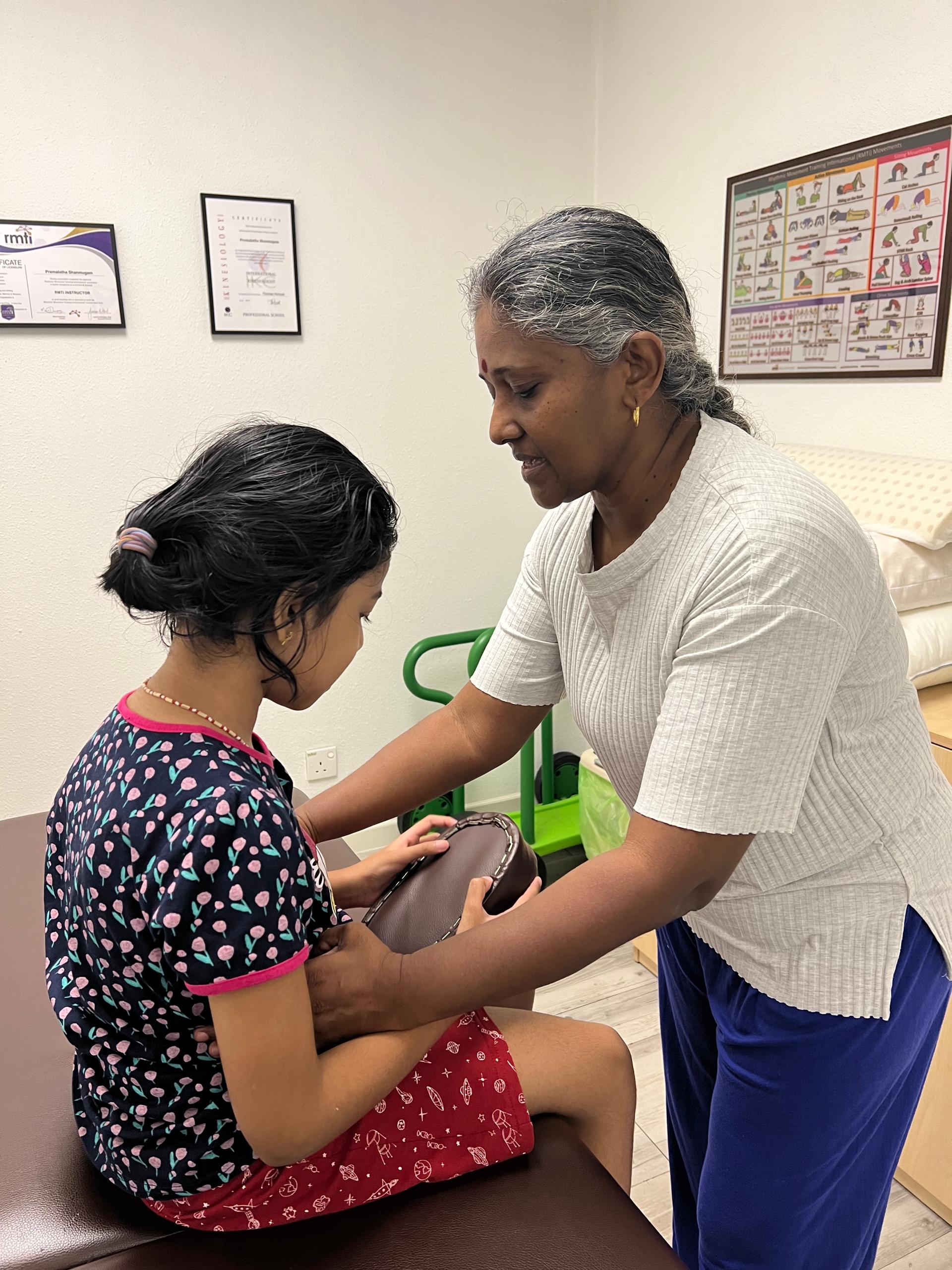 Premalatha Shanmugam, founder of kinesiology in Malaysia, giving an RMTi session to a child in Kuala Lumpur
